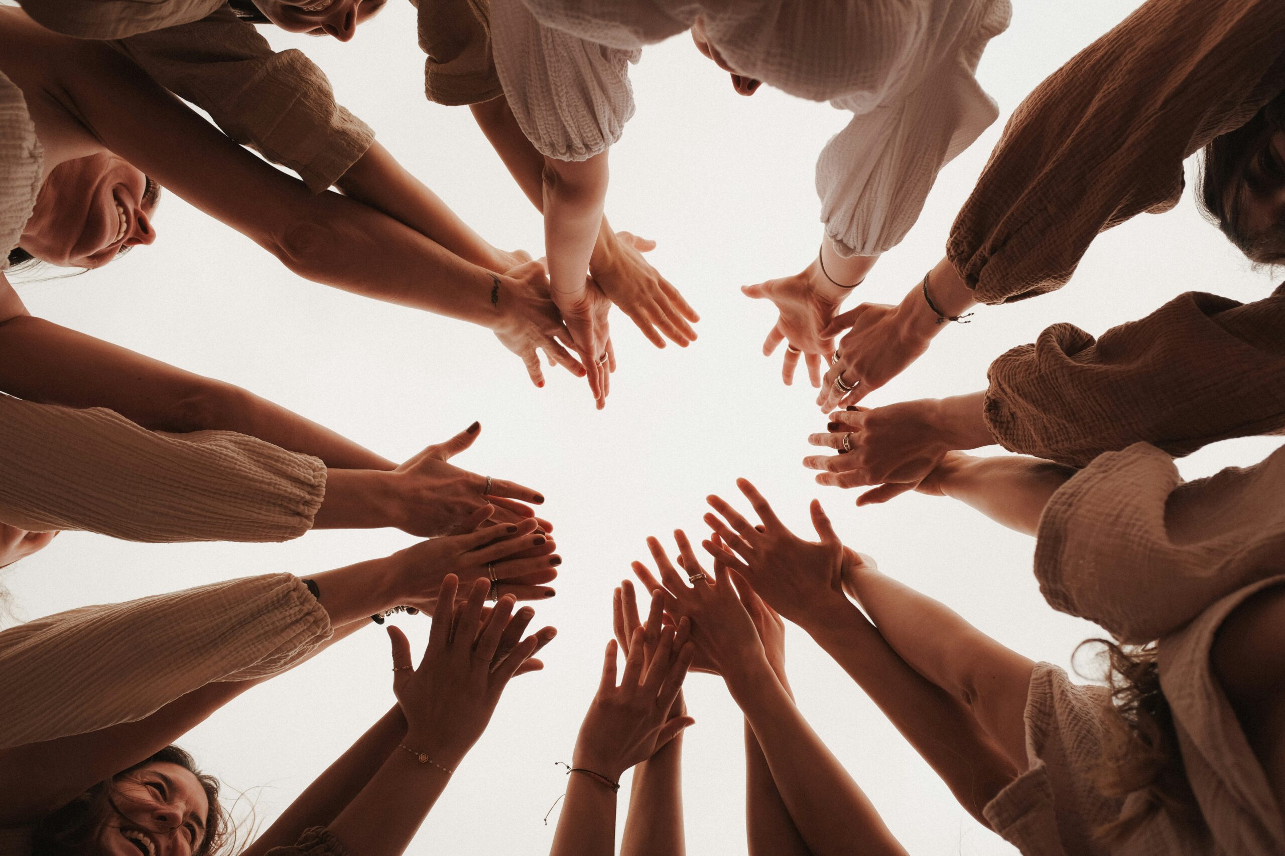 A circle of people reaching upward together, their hands extended in unity and purpose. This powerful image reflects the heart of Collective Impact—individuals and organizations lifting together toward a shared goal. In the context of foster care, it’s a picture of what’s possible when communities collaborate to provide More Than Enough for every child and family.