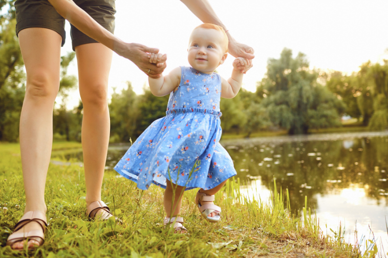 Toddler takes first steps with help from an adult, illustrating how Family Advocacy Ministry helps churches support children and families.